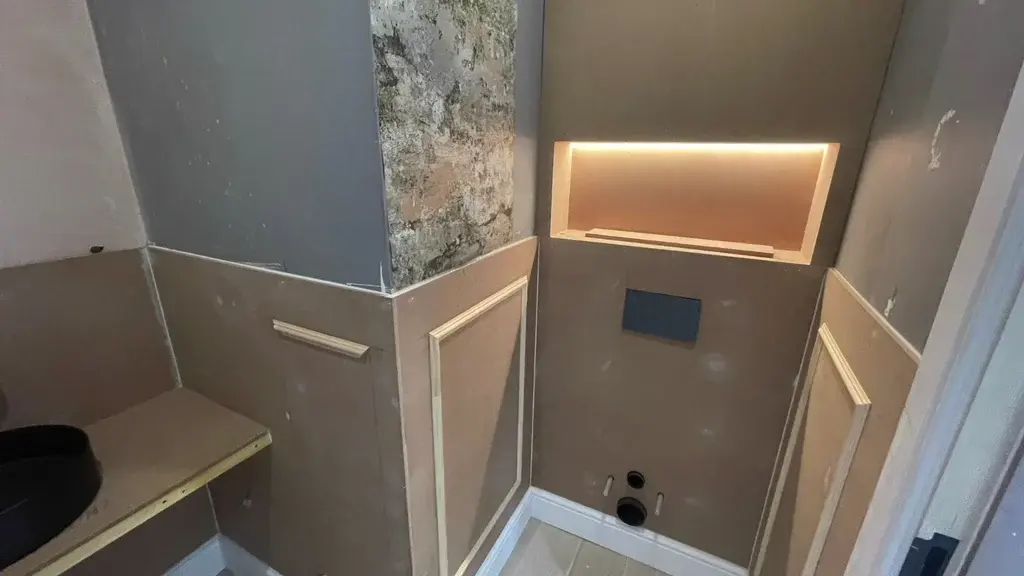 Wall panelling with an illuminated recessed niche formed in the panel run