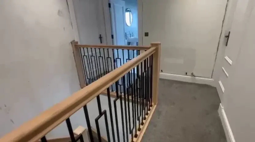Landing balustrade with timber handrail and metal spindles