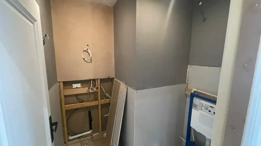 Cloakroom wall at an early construction stage, stripped back before joinery