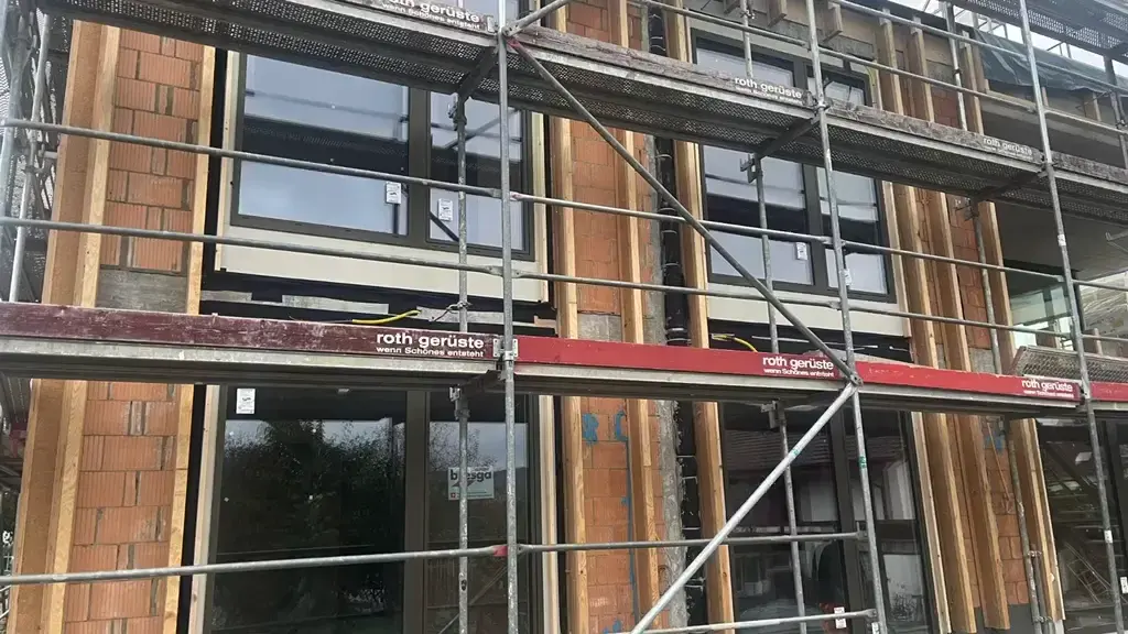 Multi-storey timber structural frame under scaffold