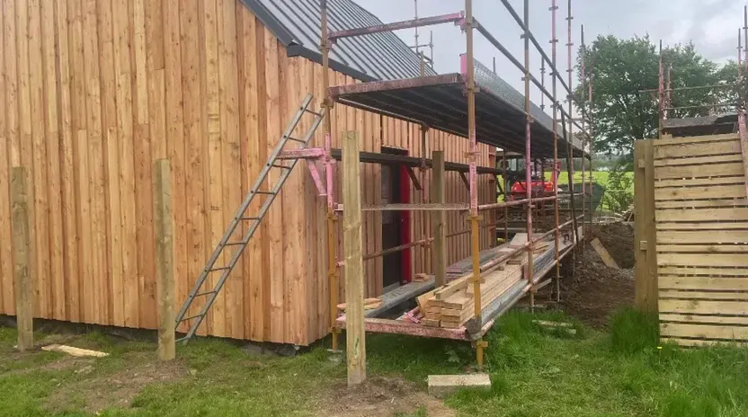 Timber board being cut on site for the vertical cladding