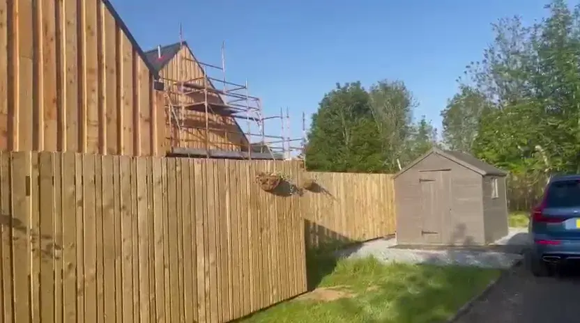 Completed vertical timber cladding on the gabled building